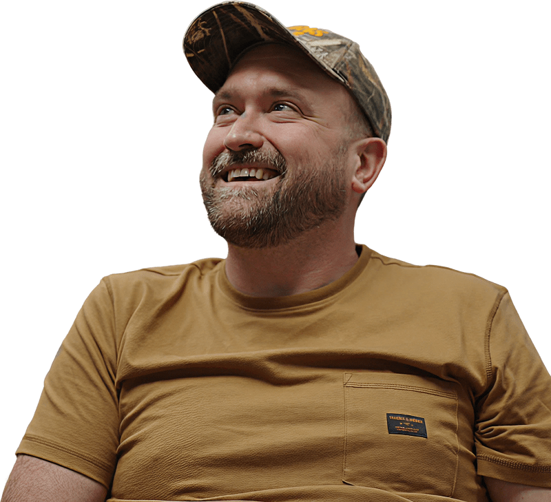 A man in a hat is joyfully smiling