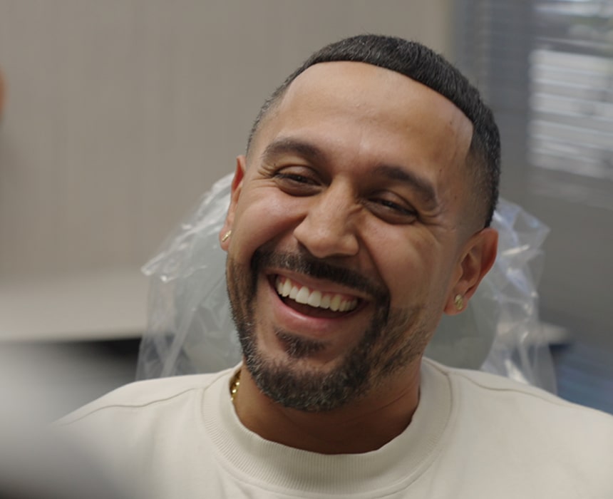 A man is smiling in a dental chair