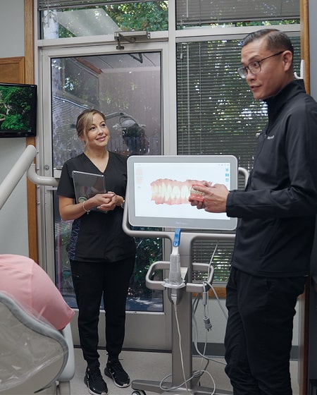 Top dentist is smiling with his assistant
