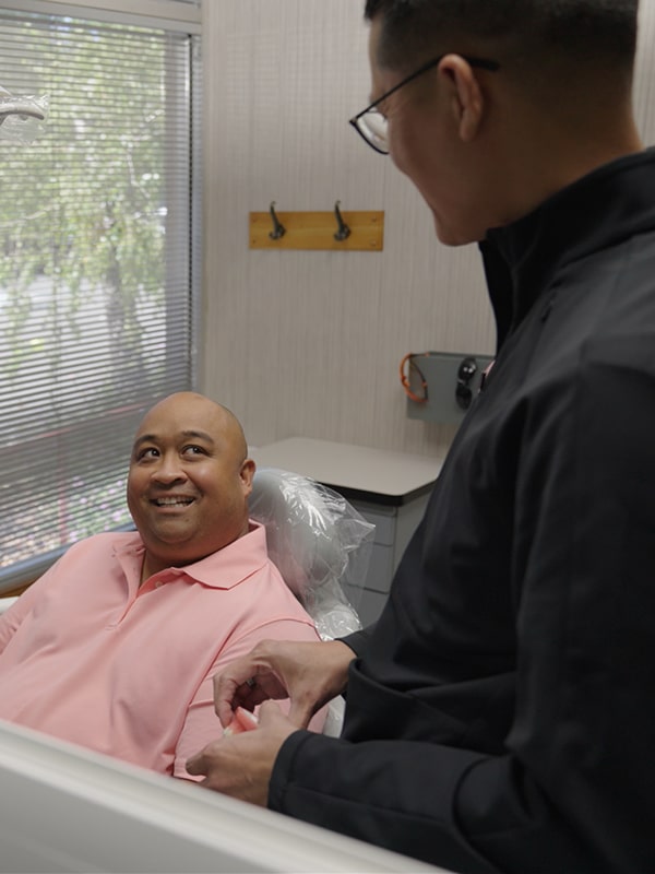 A man in a dental chair is smiling
