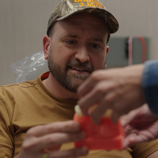 A man is smiling while looking at dental model