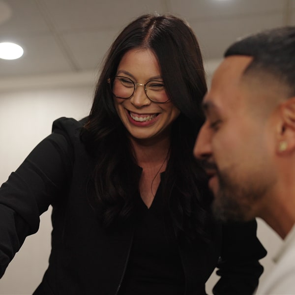 A woman in a glasses is smiling with a man on her side