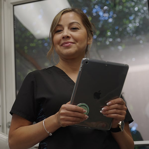 A woman is holding ipad and smiling