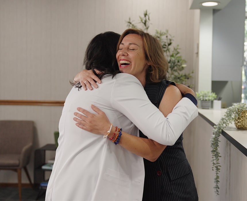 A woman is smiling and hugging her Vallejo dentist