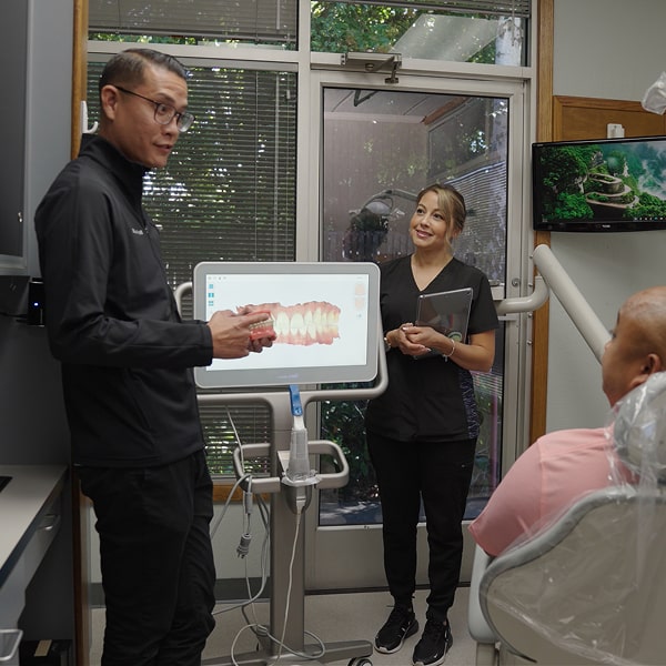Dental team is smiling with a happy patient in a dental chair