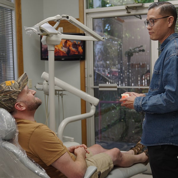 Top Vallejo dentist is smiling with his joyfull patient in a dental chair