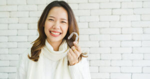 A woman holding a clear aligner